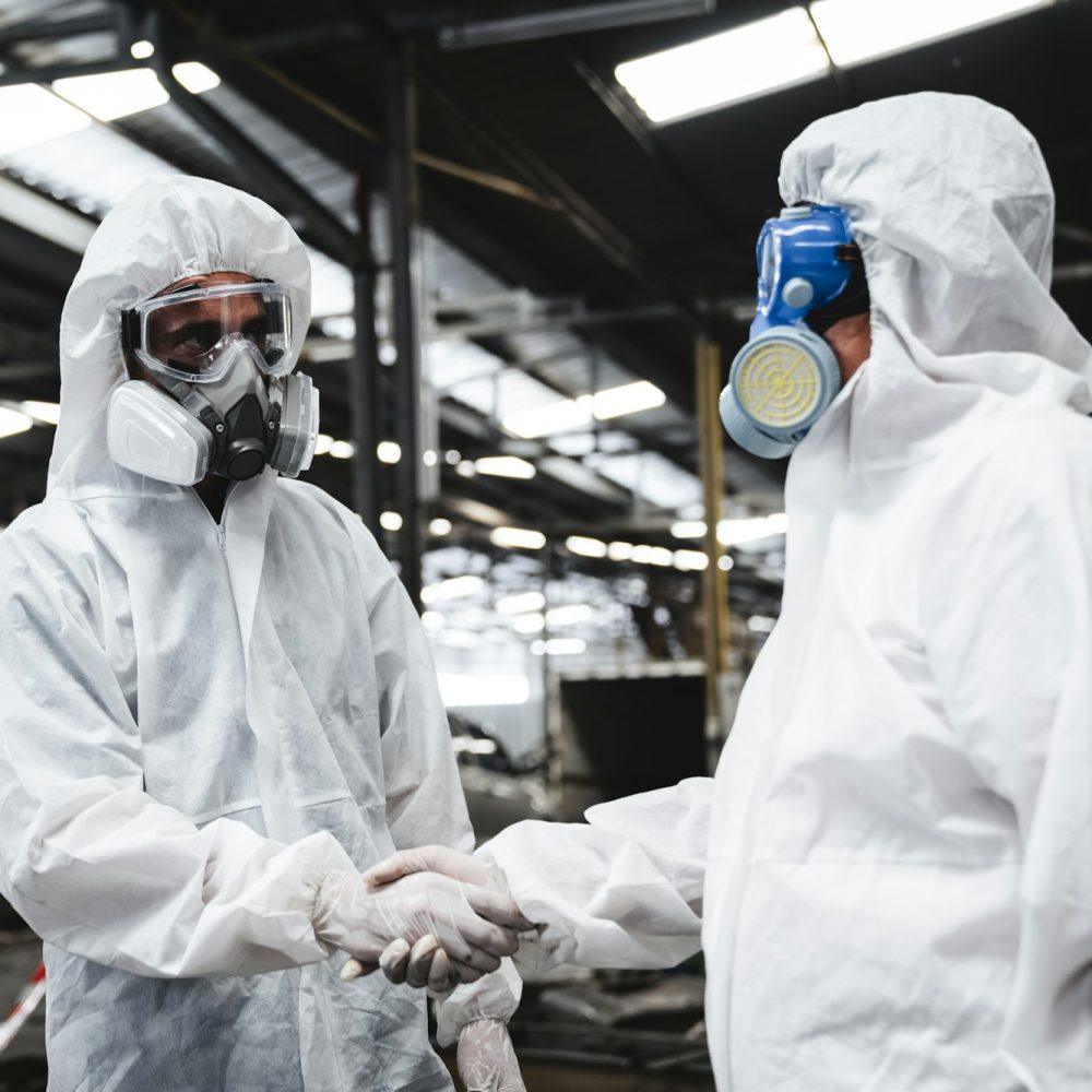 Scientist workers wear protective suit shack hand with team when working success.